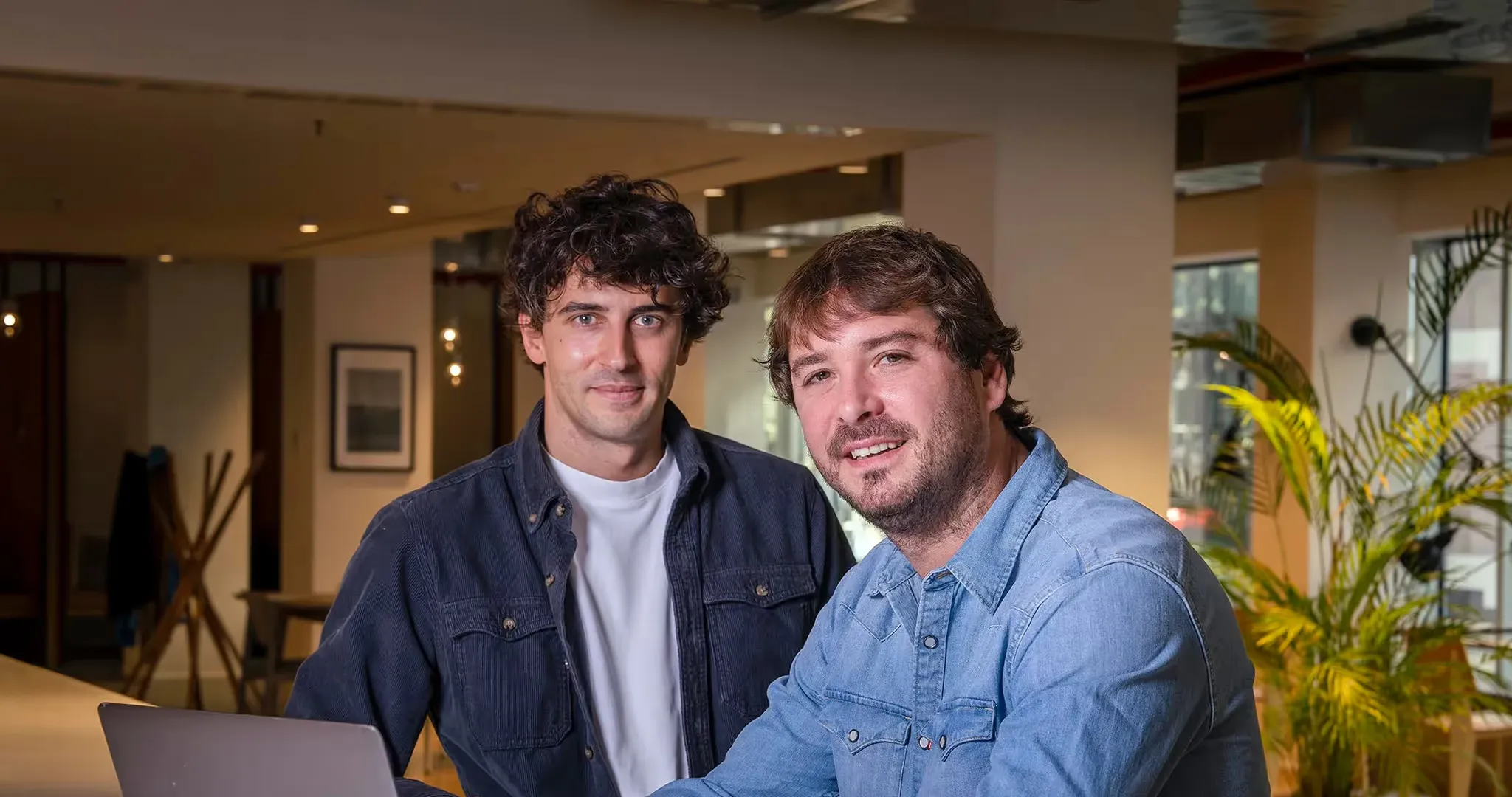 Mario Parteli e Paul Guillemin, cofondatori di Volta, seduti insieme in un ufficio, sorridenti verso la fotocamera